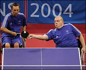 a team of ping pong players compete from wheelchairs