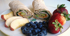 turkey roll up with sides of apples, blueberries, and strawberries