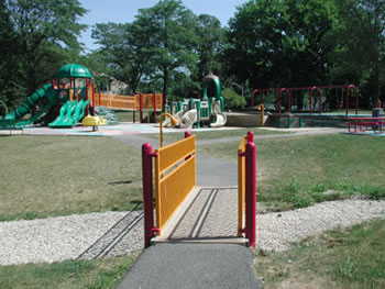 At this playground, the safety barriers are yellow, the play equipment for children 2 to 5 years old is tan with green accents, and the play equipment for children 5 to 12 years old is green.