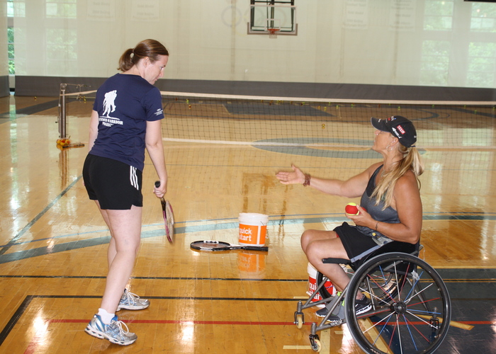 wheelchair tennis player teaching a standing player