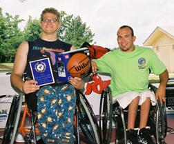 Two wheelchair athletes posing for the camera.