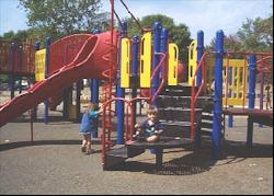 Two children playing at an accessible playground