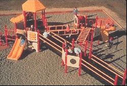 Top view of an accessible playground shows 6 children playing and a ramp passing through the floor plan.