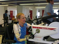 Image of a woman with right arm prosthesis using an arm ergometer