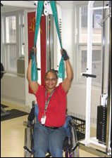 A woman is seated demonstrating a start position for a Lat Pull Down with Thera-Band® exercise