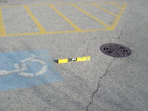 Photo showing the parking lots accessiblity problem: the slope near the drain is nearly double the maximum slope allowed