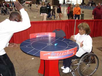 Two individuals (one using a wheelchair) play a game of Bulletball.
