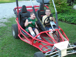 Two young boys in a go-cart.