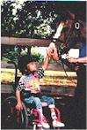 Child who uses wheelchair petting horse