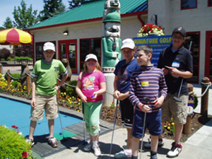 Five kids standing with a golf club