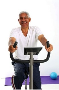 A man is smiling while using a stationary bike