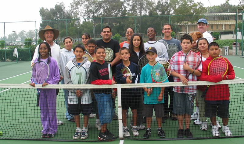 A group of children in the DhhEAF program are standing at a tennis net