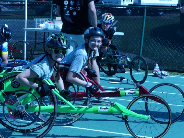 kids prepare for a track event in racing chairs