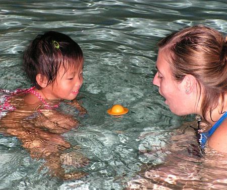 an instructor helps a child get comfortable in the water