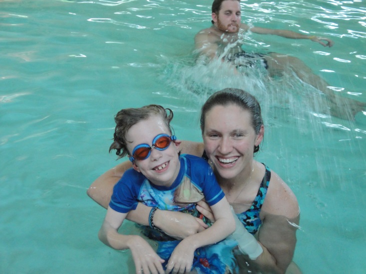 a woman holds a child in a pool