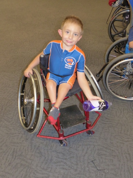 a boy in a wheelchair does a bicep curl