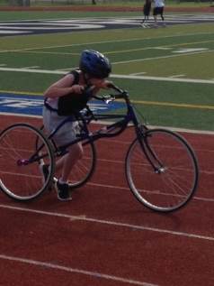 Jody Putman participating in a track and field event with an assistive rolling device