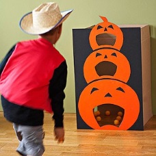 a boy plays the pumpkin toss game