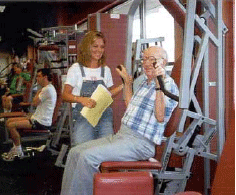 An older man who has Alzheimer's Disease is exercising with a staff person