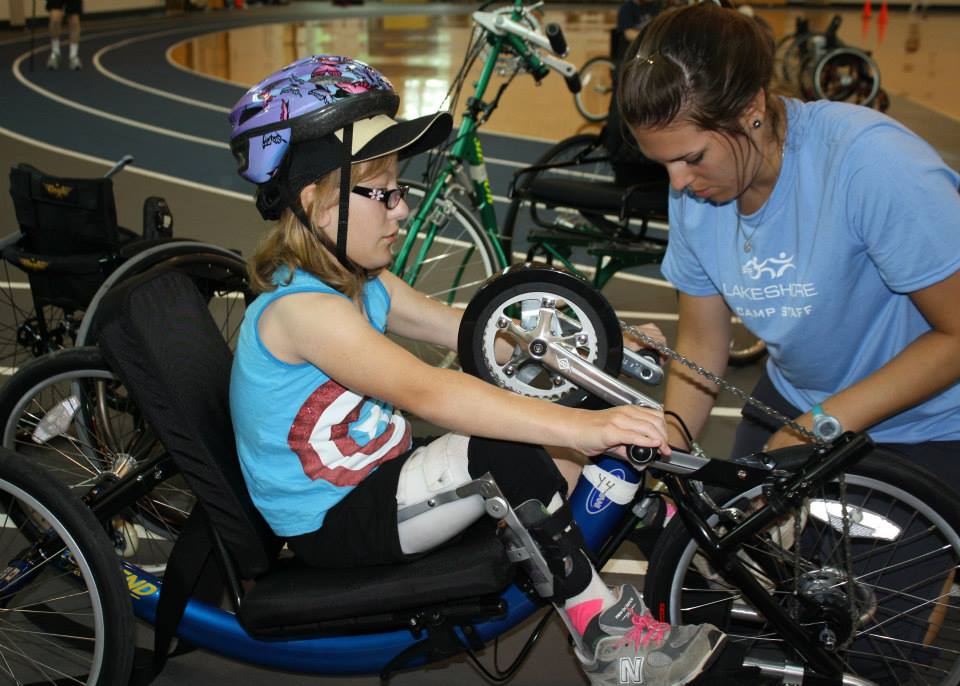 professional helping a child with handcycle maintenance