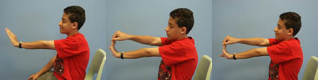 Child with Spina Bifida is performing Wrist Flexion / Extension exercises from a seated position.