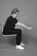 A woman is seated on chair demonstrating midback stretch