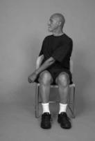 A man is seated on chair demonstrating trunk rotation