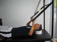 A man uses  the trapeze table to work on scapular stabilization