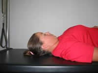 A woman is lying down readying herself to demonstrate head nods.