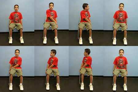 Child with Spina Bifida is performing a Trunk Rotation exercise from a seated position.