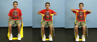 Child with Spina Bifida is performing an Upright Row exercise from a seated position.