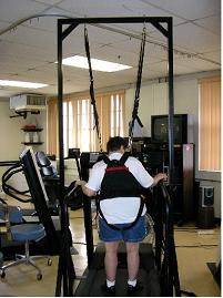 A man on a treadmill attached to a harness and suspension system.