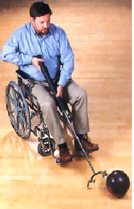Man using a wheelchair pushing a bowling ball with a ball pusher