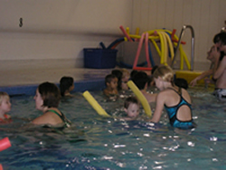 Group of children and adults in an indoor swimming pool