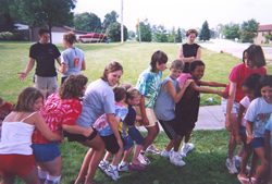 Group of children playing with adults supervising