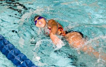 Girl doing the freestyle stroke in a swimming competition 