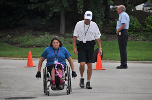 A woman pushing her wheelchair and a man walking during the Breast Cancer 3-Day Walk