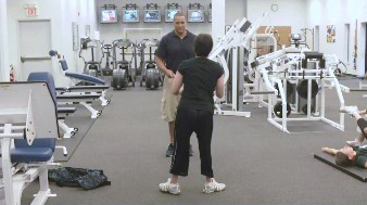 A woman and a man are standing in a fitness center.