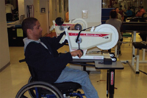 Wheel chair user exercising on a table-top upper body cycle