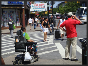Photo of a person in wheelchair crossing a street