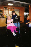 An older woman who has Alzheimer's Disease is exercising with a staff person