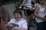 Smiling female camper who is using a wheelchair with other campers in the background.